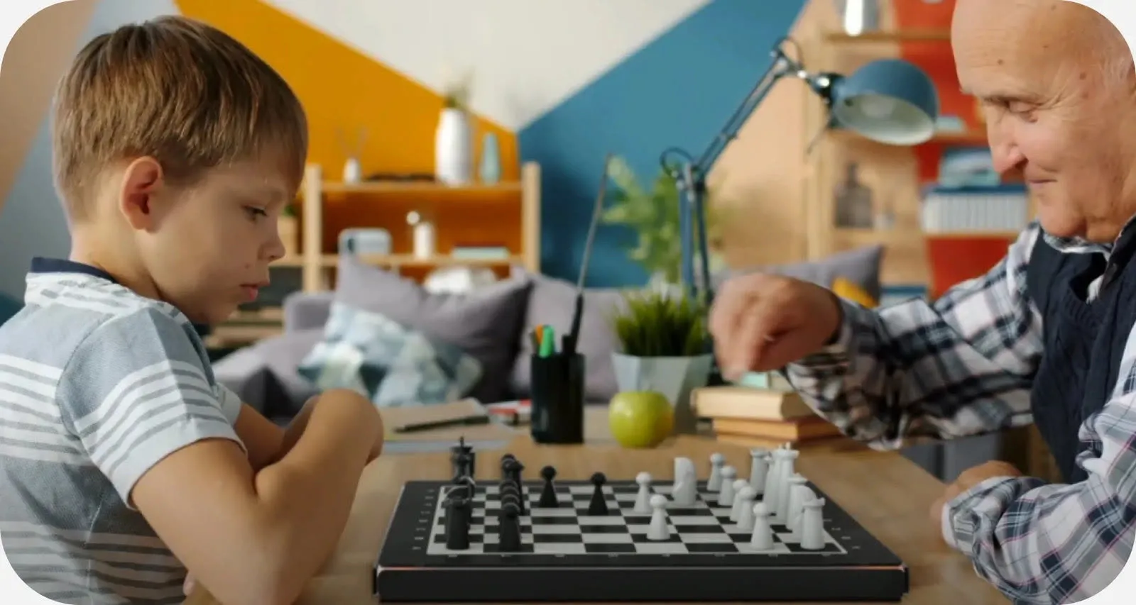 A grandfather and grandson playing on GoChess at a kitchen table